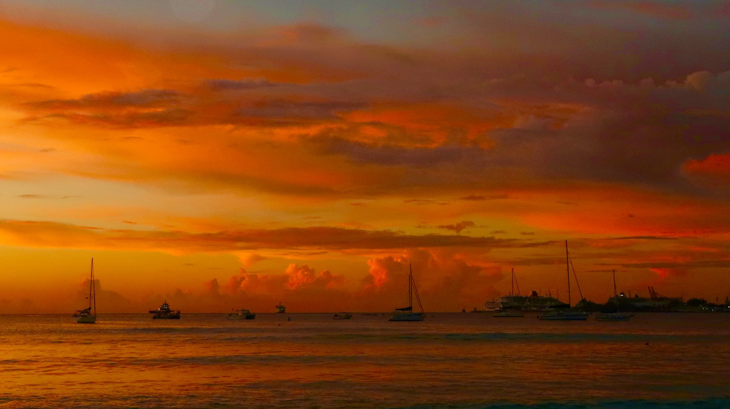 Boats at anchor, burning sky — A harbor evening